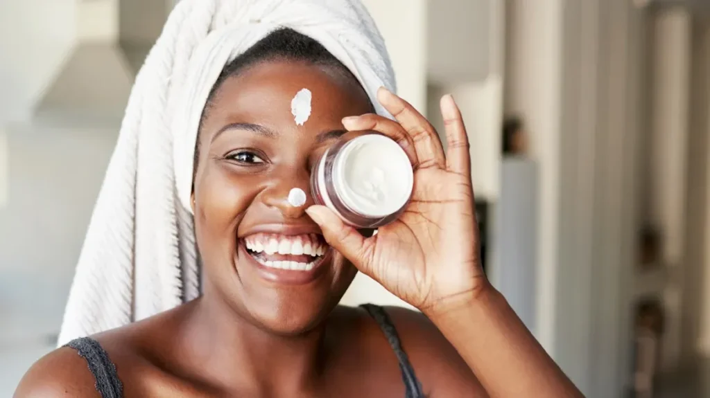 woman holding up a face cream 1296x728 header